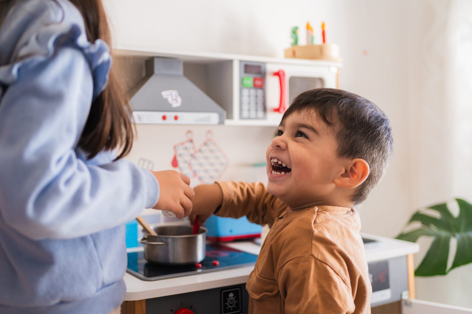 Happy children playing with toy kitchen set, cooking and having fun Happy children playing with toy kitchen set, cooking and having fun